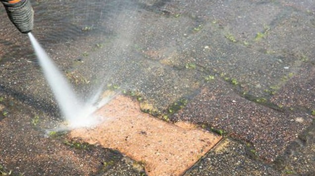 this is an image of a person using pressure wash to clean their patio and improve the curb appeal of their home