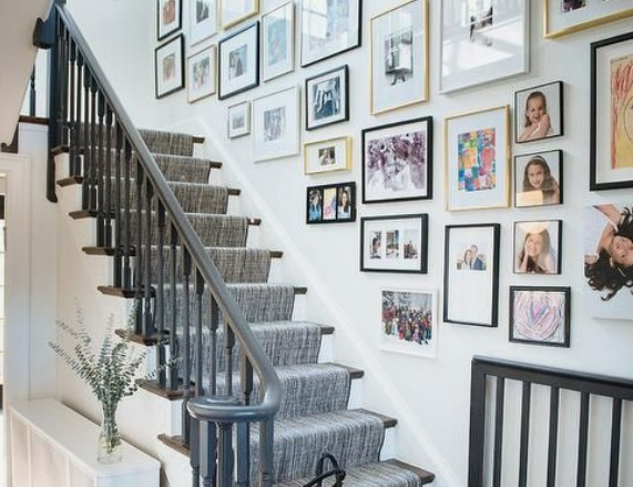this is an image of sidewall of stairs decorated with framed 