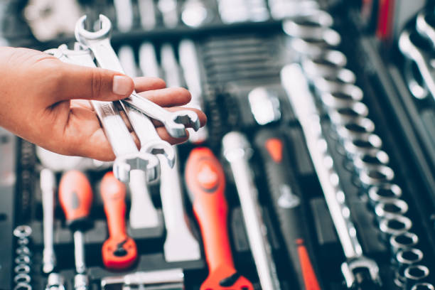 Tool hardware store. Closeup of male hand holding wrenches and spanners. Auto repair kit in toolbox. Repairman instruments for car tool kit