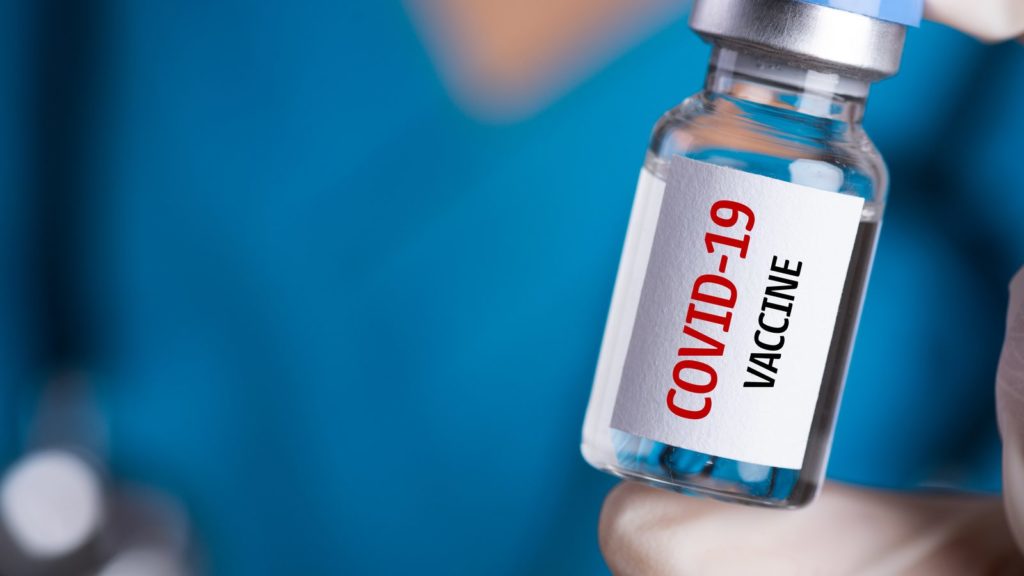 Person holding a COVID-19 Vaccine