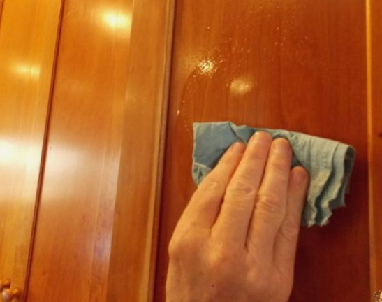 a person cleaning kitchen cabinets 