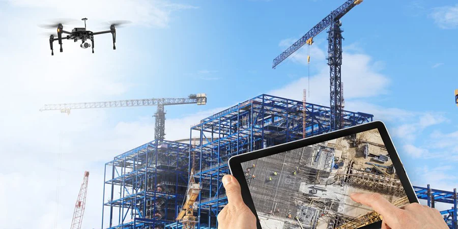 a person surveying the construction site with the help of a drone camera