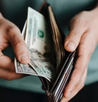 a person taking money out of his wallet