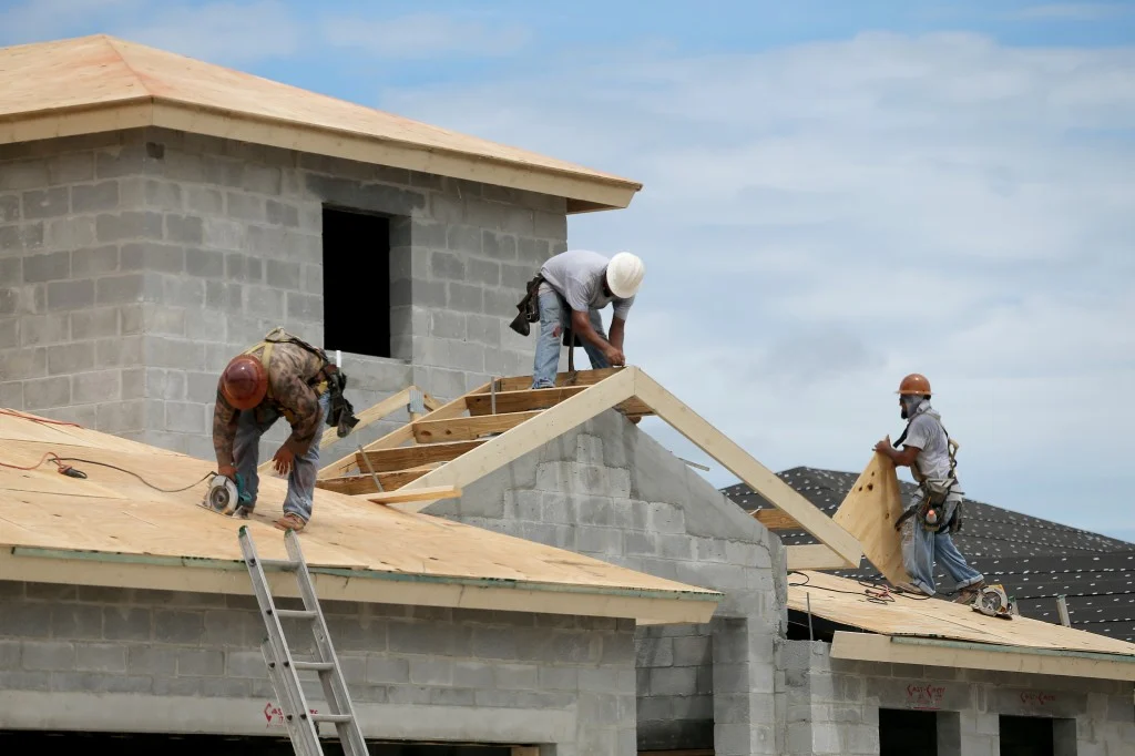 Masons building a house's roof