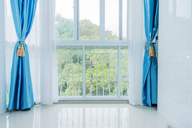 کمرے کی کھڑکی میں نصب نیلے رنگ میں خوبصورت پردے
