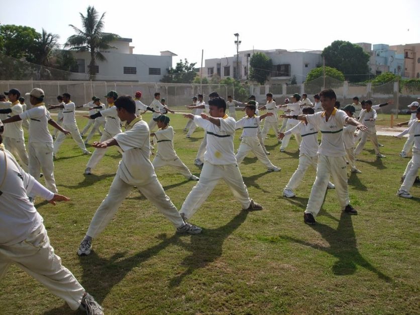 Students wearing uniform and doing PT exercise in PIA Cricket Academy