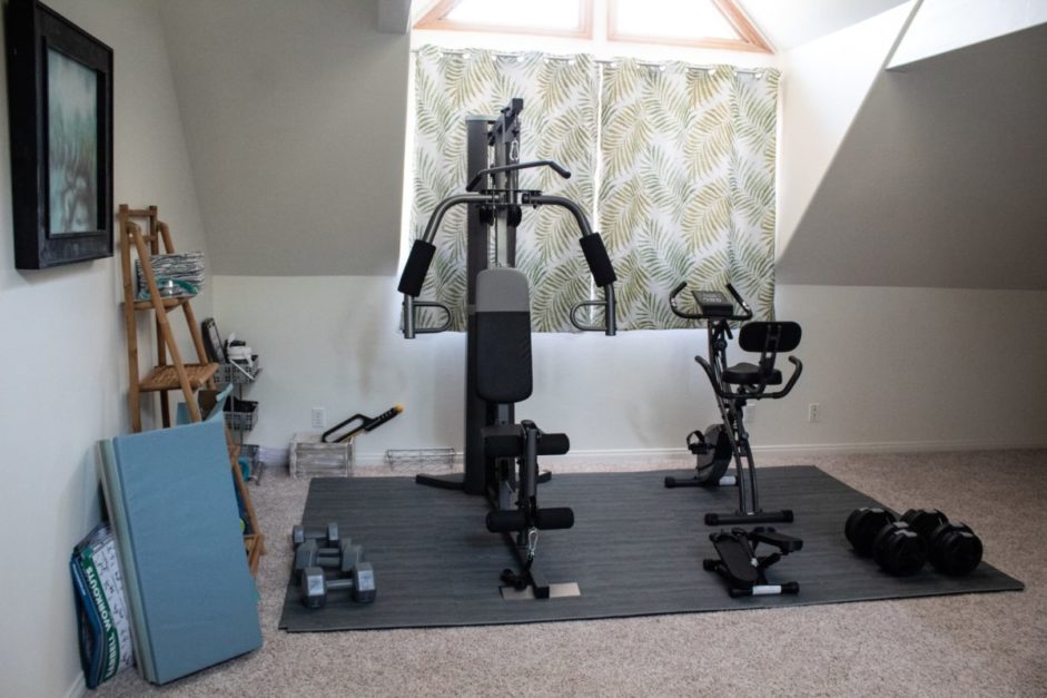 a home gym with bicycle machine and yoga mat 